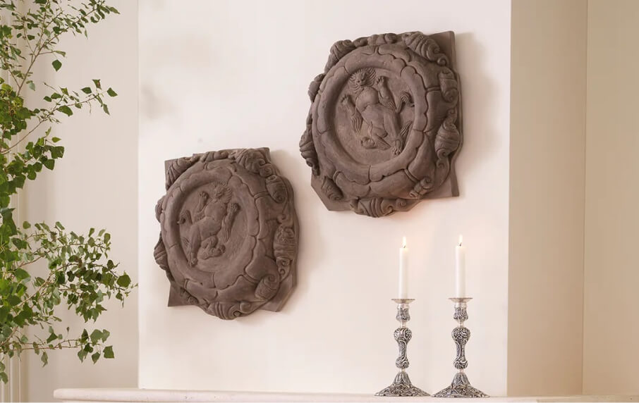 Decorative wall plaques with intricate designs on a light-colored wall.