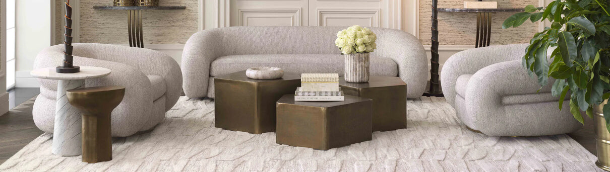 Where Local Spirit Meets Global Design- Modern living room with gray sofa, wooden coffee tables, and decorative elements.